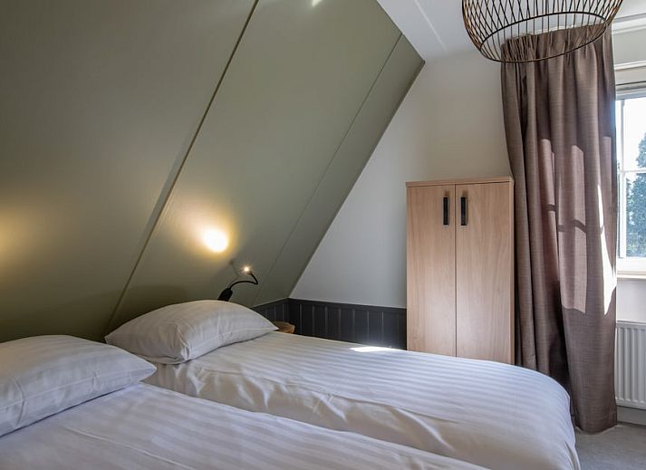 Gemuetliches Wohnzimmer des Bungalows FV14 Comfort Plus in Oosterhout, Westbrabant, mit Blick auf die Terrasse und die gruene Umgebung.