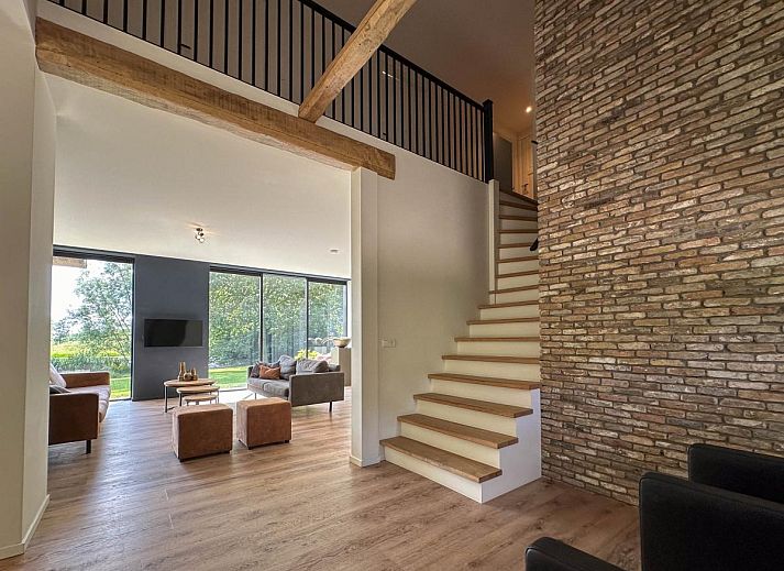 Gemuetliche Sitzecke im Ferienhaus De Karkooi in Rijsbergen mit grossen Fenstern.