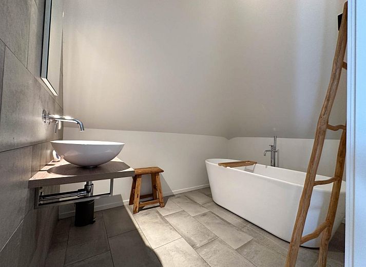 Gemuetliche Sitzecke im Ferienhaus De Karkooi in Rijsbergen mit grossen Fenstern.