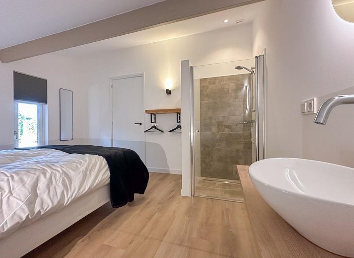 Dining area in De Stal vacation home in Rijsbergen, North Brabant with large dining table and atmospheric lighting.