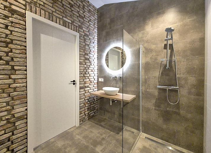 Dining area in De Stal vacation home in Rijsbergen, North Brabant with large dining table and atmospheric lighting.