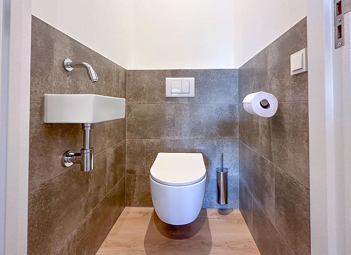 Dining area in De Stal vacation home in Rijsbergen, North Brabant with large dining table and atmospheric lighting.