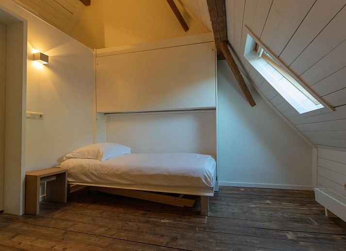 Interior of Jager en Hooijmijt vacation home in Ulvenhout AC, West Brabant, with wooden beams and cozy seating areas.