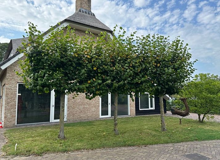 Gezellig terras met open deur bij Vakantiehuis in Herpt, ideaal voor een zomerse dag in Noord Brabant.