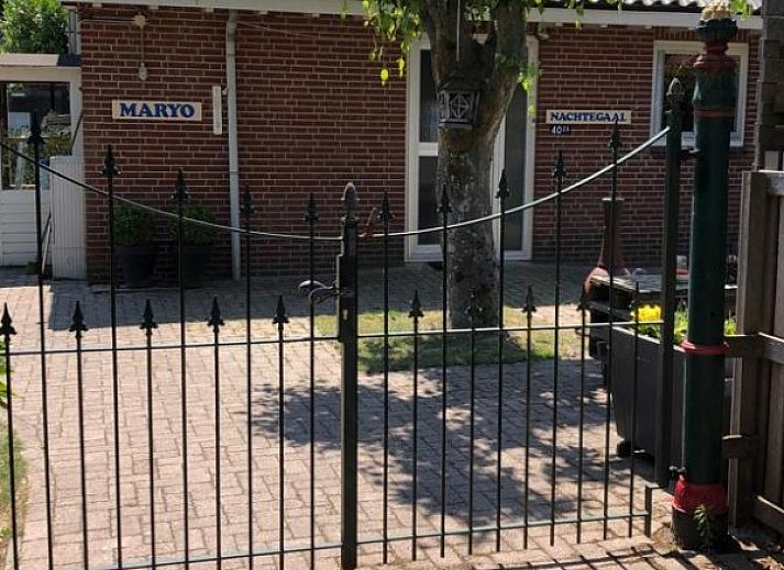 Entree van vakantieverblijf MARYO in Schoorl, Noordzeekust, Noord-Holland met boom en bakstenen gevel.