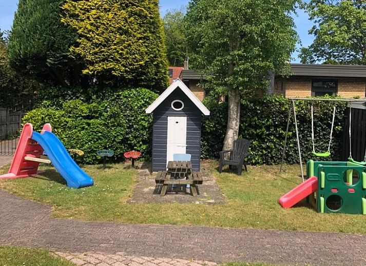 Entree van vakantieverblijf MARYO in Schoorl, Noordzeekust, Noord-Holland met boom en bakstenen gevel.
