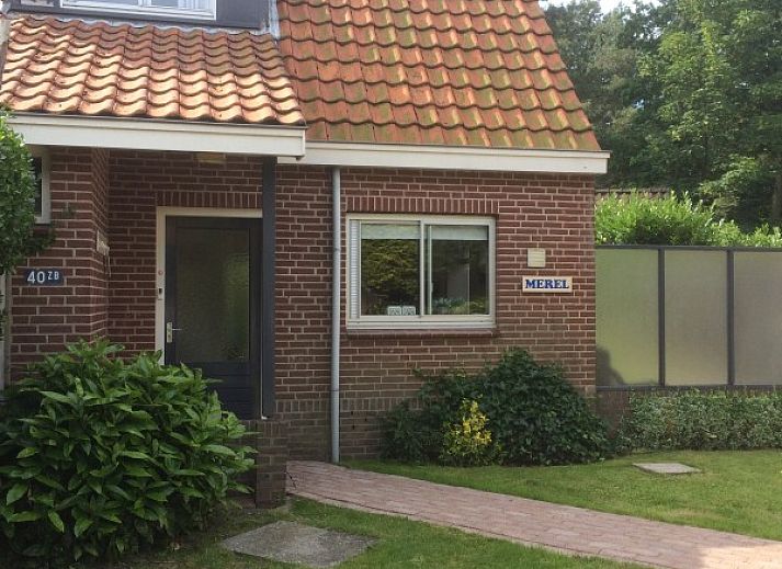 Entree van vakantieverblijf MARYO in Schoorl, Noordzeekust, Noord-Holland met boom en bakstenen gevel.
