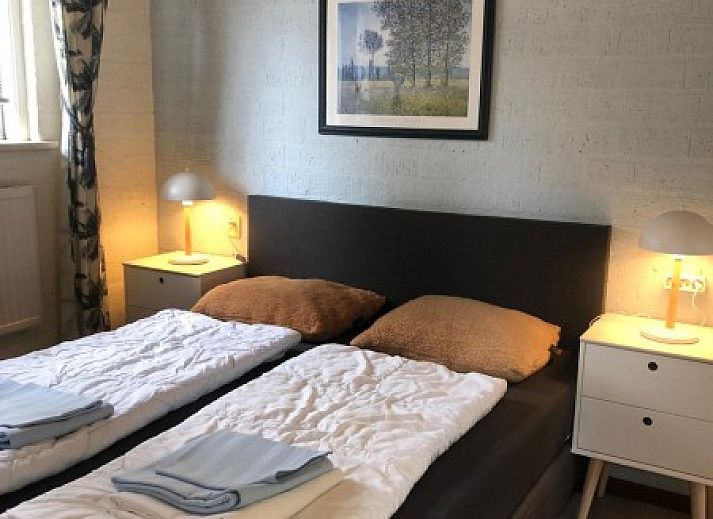 Gezellige slaapkamer in vakantieverblijf MARYO, Schoorl, Noordzeekust, Noord-Holland met rotan stoel.