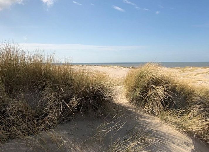 Gezellige slaapkamer in vakantieverblijf MARYO, Schoorl, Noordzeekust, Noord-Holland met rotan stoel.