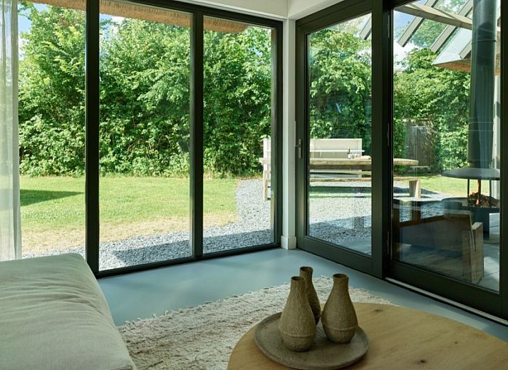 Gezellige buitenruimte van 8 pers villa met sauna in Schoorl, Noordzeekust, omgeven door groene natuur.