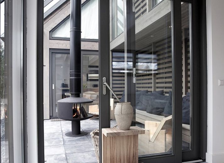 Gezellige buitenruimte van 8 pers villa met sauna in Schoorl, Noordzeekust, omgeven door groene natuur.