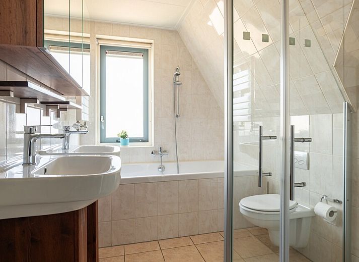 Stijlvolle woonkamer in Villa Luxe 6, een vakantiehuis in Julianadorp aan de Noordzeekust, Noord-Holland, met moderne inrichting en veel licht.