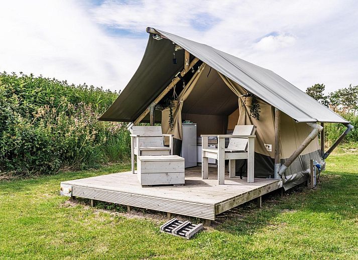 Duolodge 2 personen in Julianadorp biedt een knusse glamping ervaring aan de Noordzeekust met een charmante veranda en groene omgeving.