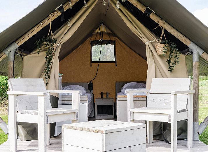 Duolodge 2 personen in Julianadorp biedt een knusse glamping ervaring aan de Noordzeekust met een charmante veranda en groene omgeving.