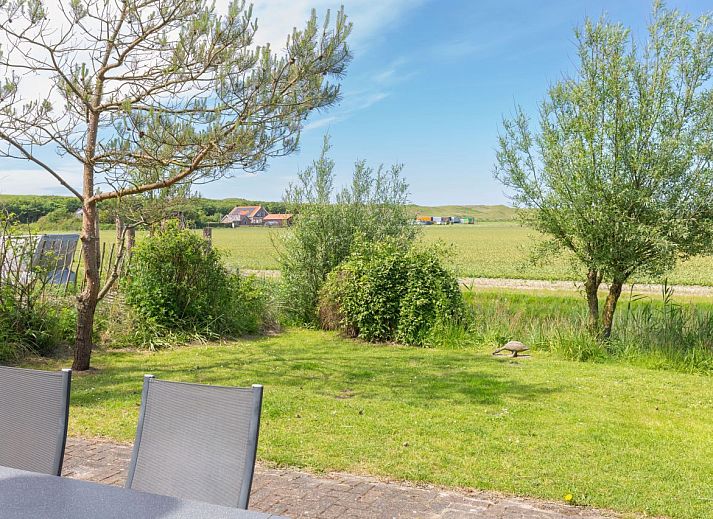 Ingang van Vrijstaande woning in Julianadorp, een vakantiehuis aan de Noordzeekust in Noord-Holland, met een uitnodigend pad en groene omgeving.