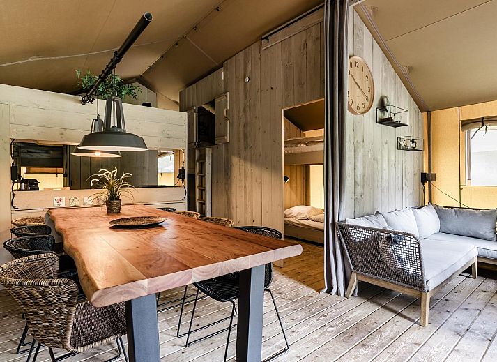 Strandtent 8 personen in Julianadorp, Noord-Holland, biedt een glamping ervaring met een ruime veranda en uitzicht op de groene omgeving.