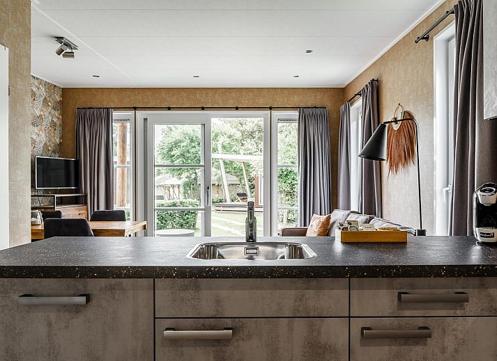 Gezellige woonkamer in Strandhuisje 4 personen in Julianadorp, Noordzeekust, met uitzicht op de tuin.