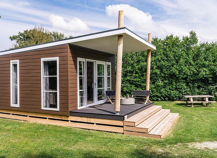 Gemuetliches Wohnzimmer der Strandhuisje 4 Personen in Julianadorp, Nordseekueste. Gemuetliche Sitzecke mit Blick auf die gruene Umgebung.