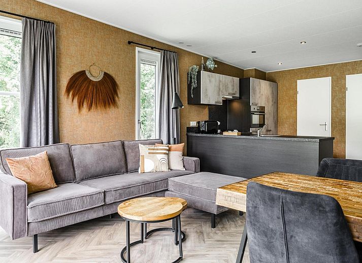 Gemuetliches Wohnzimmer der Strandhuisje 4 Personen in Julianadorp, Nordseekueste. Gemuetliche Sitzecke mit Blick auf die gruene Umgebung.