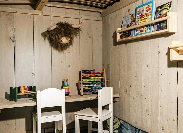 Innenansicht des Strandzeltes fuer 6 Personen in Julianadorp, Nordholland. Gemuetliche Glamping-Lodge mit Holzinterieur und komfortabler Sitzecke.