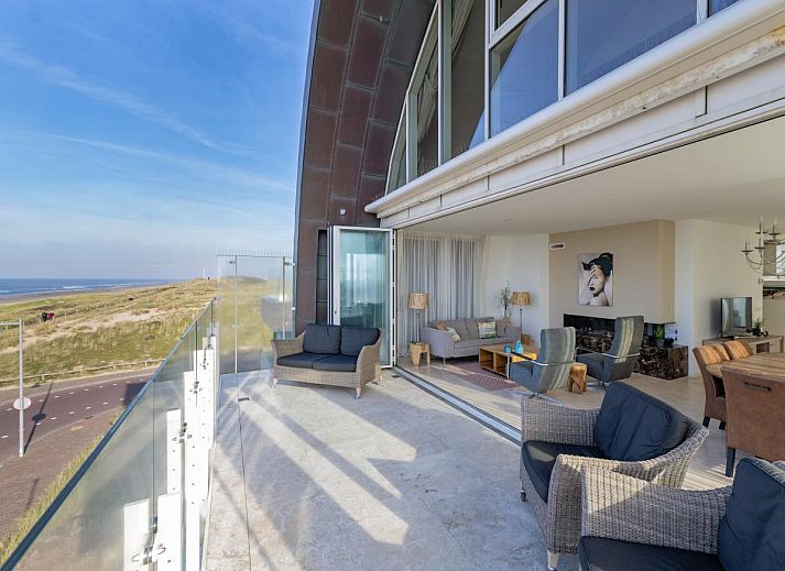 Geraeumige Terrasse des Ferienhauses De Garnaal in Egmond aan Zee mit Blick auf die Nordseekueste und modernem Innenbereich.