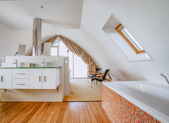 Stilvolles Wohnzimmer des Ferienhauses De Garnaal in Egmond aan Zee an der Nordseekueste mit moderner Einrichtung und viel Tageslicht.