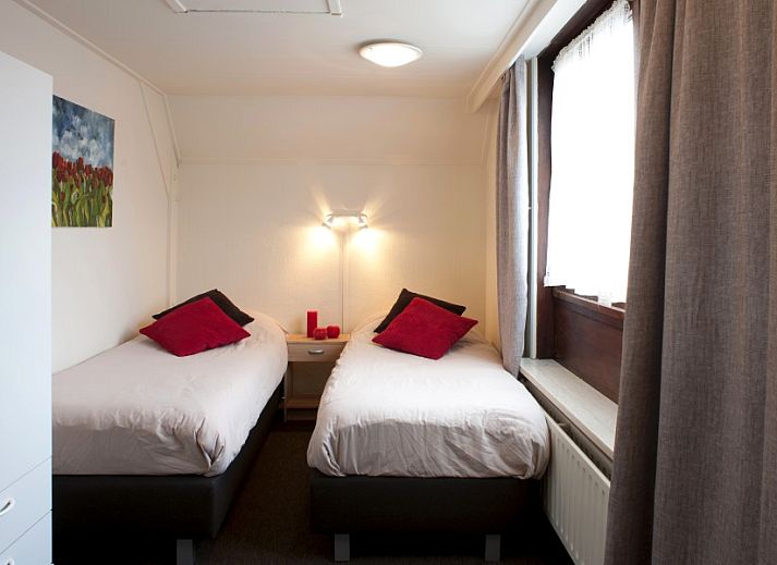 Gemuetliches Wohnzimmer in der Wohnung De Klok III, Egmond aan Zee, Nordseekueste, mit bequemer Sitzecke und Kueche.