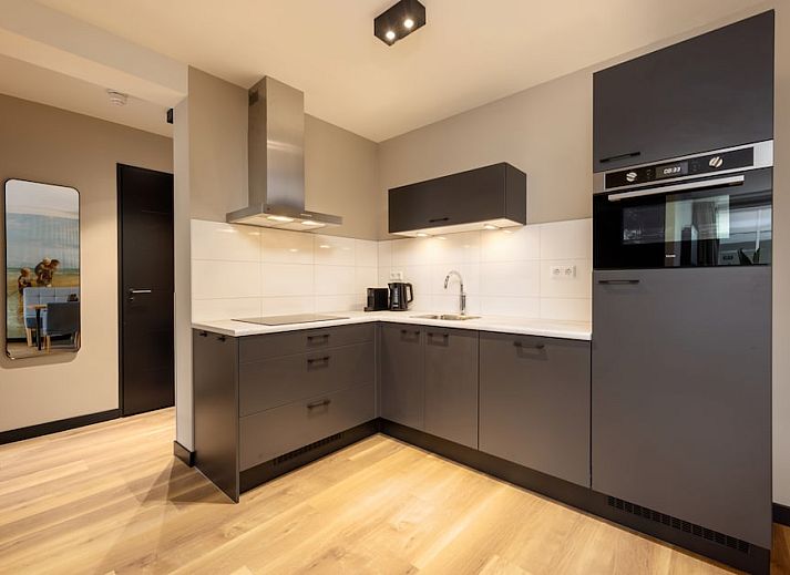 Stylish living room of Apartment 3B in Egmond aan Zee, North Sea coast, North Holland with balcony and modern furnishings.