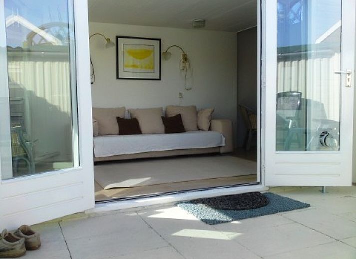 Lichte woonkamer in zomerhuis DEZEESTER, Egmond aan Zee, met comfortabele zithoek en moderne inrichting.