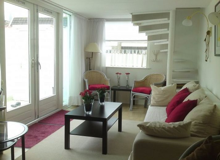 Lichte woonkamer in zomerhuis DEZEESTER, Egmond aan Zee, met comfortabele zithoek en moderne inrichting.