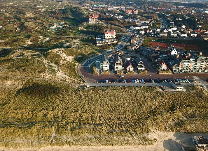 Modernes Wohnzimmer des Ferienhauses Zeebaars in Egmond aan Zee mit offener Kueche und Gartenblick, Nordseekueste, Nordholland.