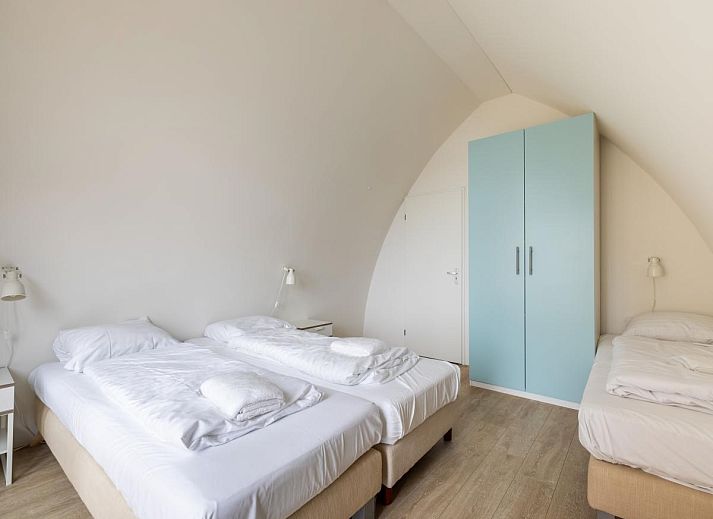 De Platvis vacation home in Egmond aan Zee with a view of the North Sea coast from the bedroom and an inviting terrace.