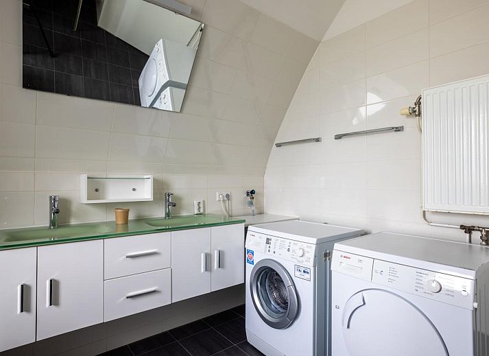 Cozy living room of vacation home De Platvis in Egmond aan Zee, North Sea coast, North Holland, with comfortable furnishings and a view of the terrace.