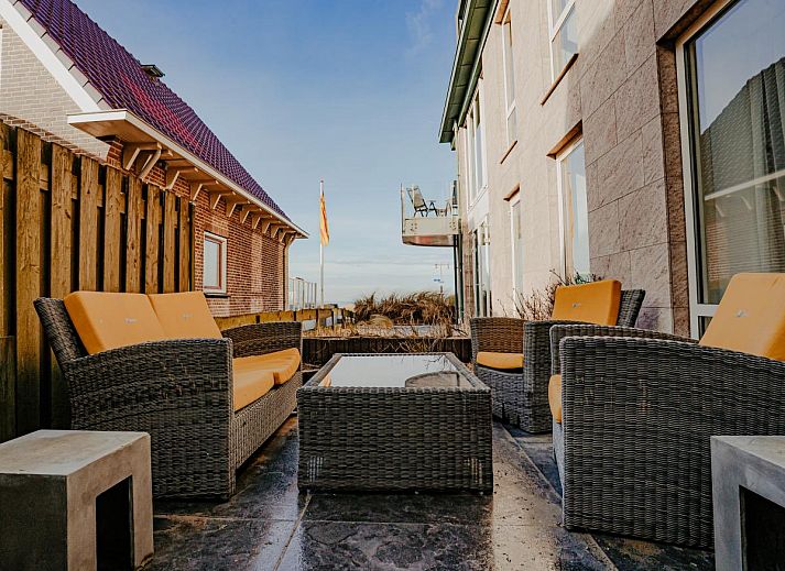 Cozy living room of vacation home De Platvis in Egmond aan Zee, North Sea coast, North Holland, with comfortable furnishings and a view of the terrace.