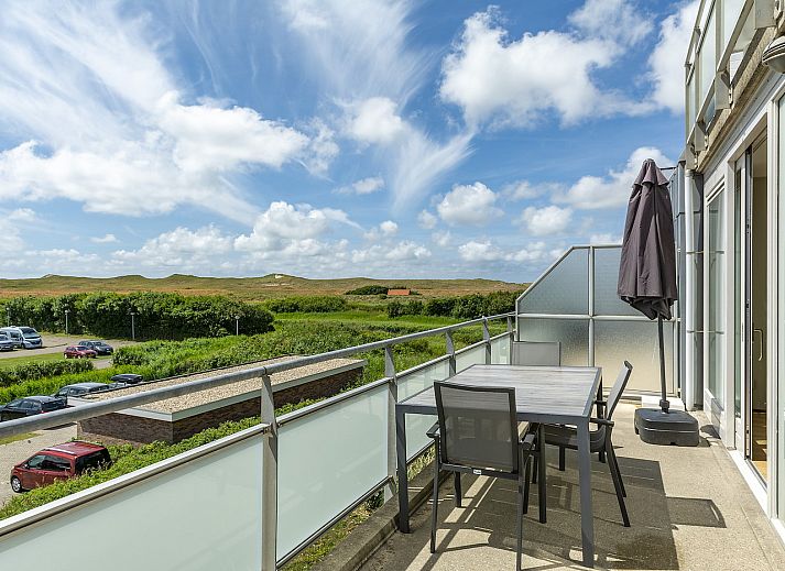 Terrasse des Ferienhauses Duinerei B202 Groote Keeten in Callantsoog mit Blick auf die Duenen und den blauen Himmel.
