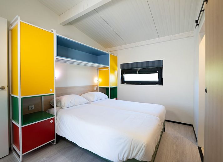 Gezellige woonkamer van Tulip Mania 4 vakantiehuis in Callantsoog, Noord-Holland, met kleurrijk interieur en moderne keuken aan de Noordzeekust.