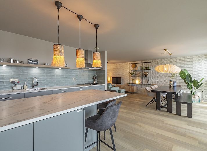 Dining room in Strandleven 006 Groote Keeten, Callantsoog with modern lighting and views of the North Sea coast.