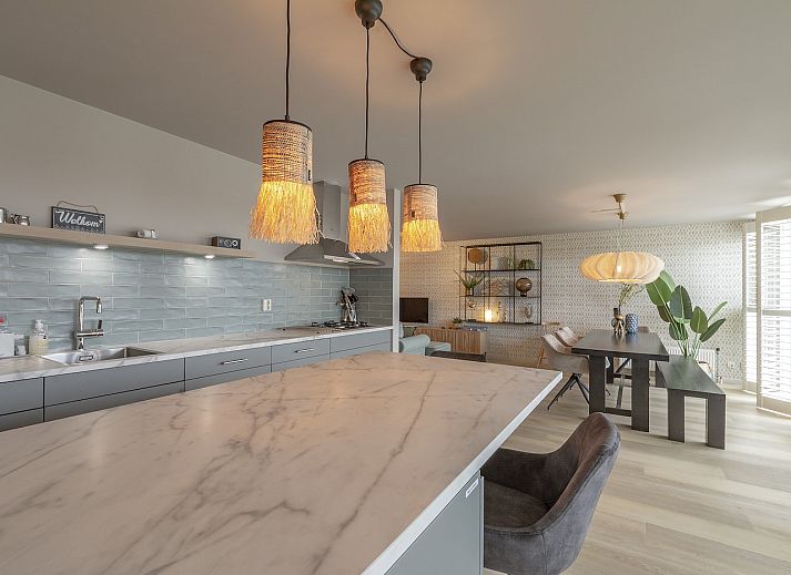 Dining room in Strandleven 006 Groote Keeten, Callantsoog with modern lighting and views of the North Sea coast.