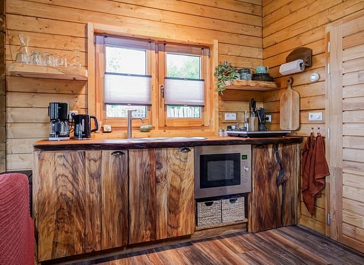 Rustikales Ferienhaus in Callantsoog, Nordseekueste, Nordholland, umgeben von gruener Natur und einer einladenden Terrasse.