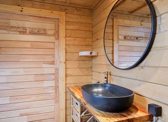 Gemuetliches Wohnzimmer des Ferienhauses in Callantsoog, Nordseekueste, Nordholland mit Holzofen und bunter Dekoration.