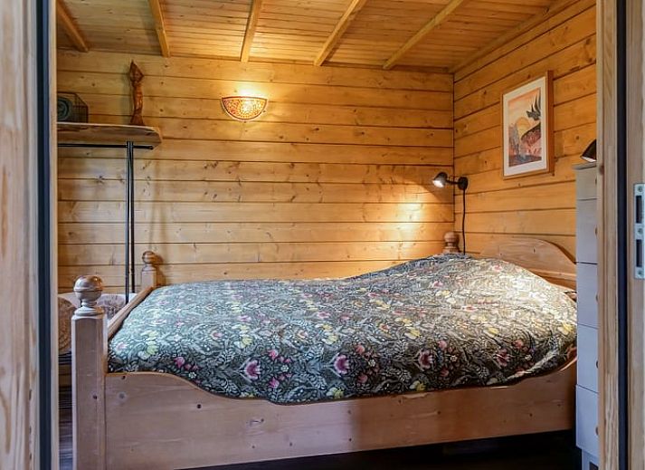 Gemuetliches Wohnzimmer des Ferienhauses in Callantsoog, Nordseekueste, Nordholland mit Holzofen und bunter Dekoration.