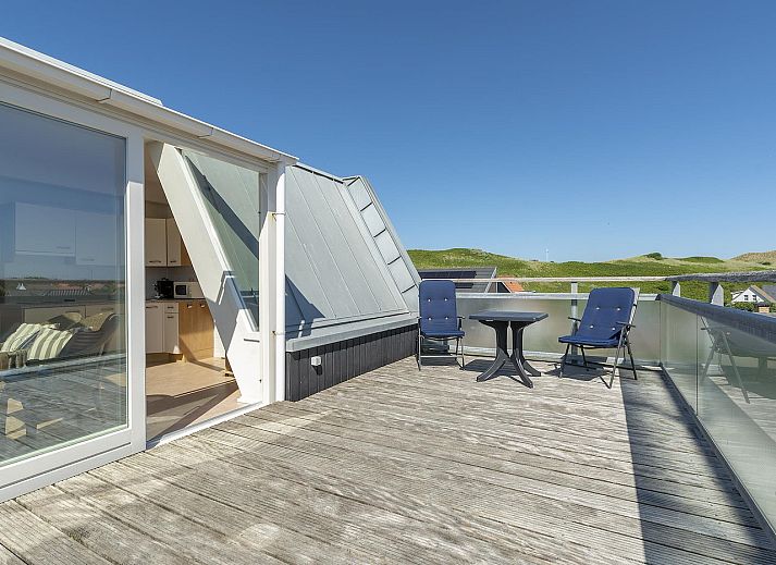 Sunny terrace at Dorpsplein 23E Callantsoog vacation home, overlooking dunes, North Sea coast, North Holland.