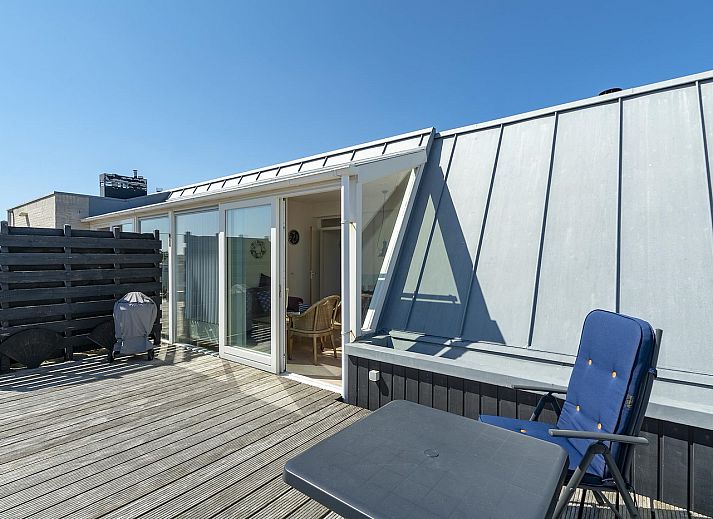 Sunny terrace at Dorpsplein 23E Callantsoog vacation home, overlooking dunes, North Sea coast, North Holland.