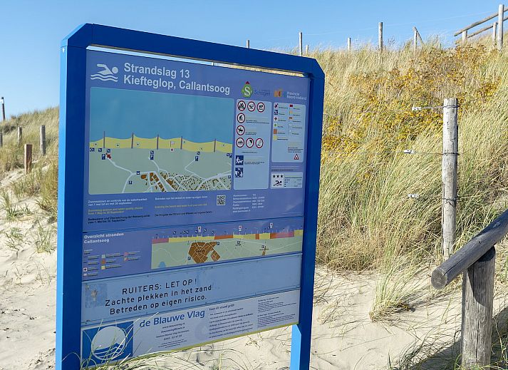 Woonkamer met uitzicht op de duinen in Wijde Blick 212 Callantsoog, Noord-Holland.