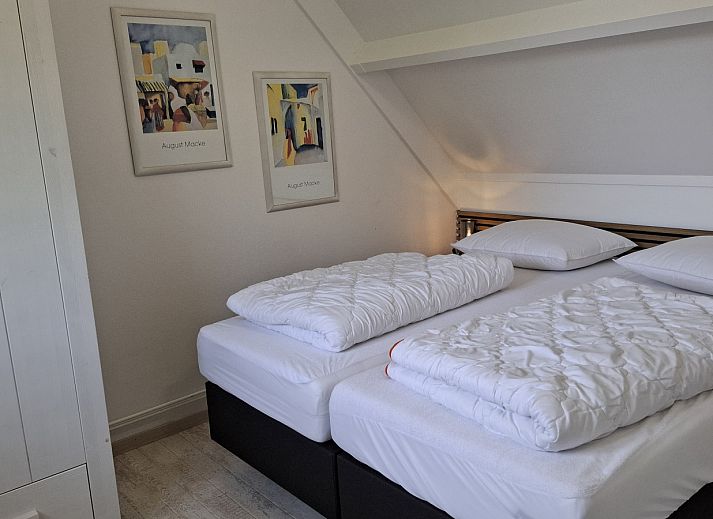 Gemuetliches Wohnzimmer im NH549, Callantsoog, Nordseekueste, mit bequemen Sitzgelegenheiten und maritimen Themen.