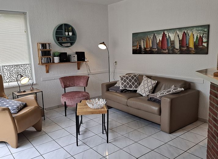 Esszimmer im Ferienhaus NH549, Callantsoog, Nordseekueste, mit Holzmoebeln und Kunst an der Wand.