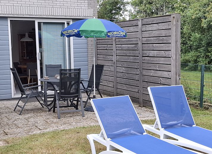 Esszimmer im Ferienhaus NH549, Callantsoog, Nordseekueste, mit Holzmoebeln und Kunst an der Wand.