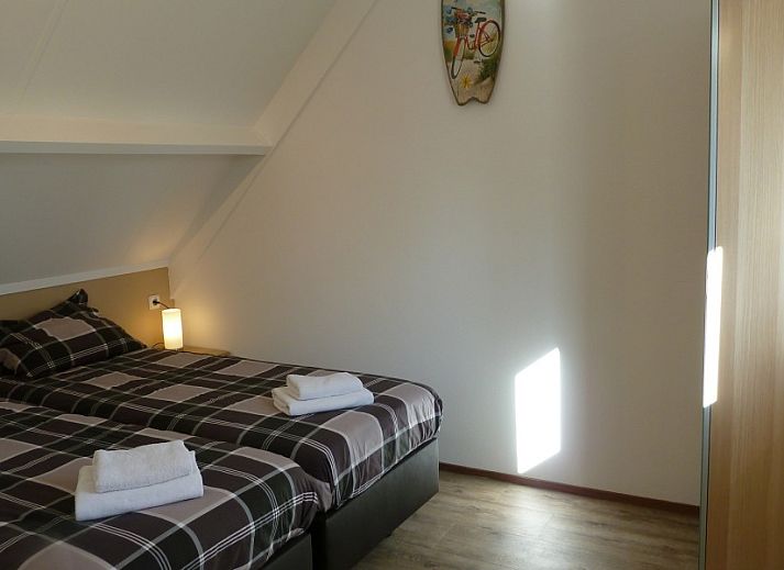 Buitenkant van vakantiehuis Korre 2 aan de Noordzeekust in Callantsoog, Noord-Holland, met charmante rode deuren.