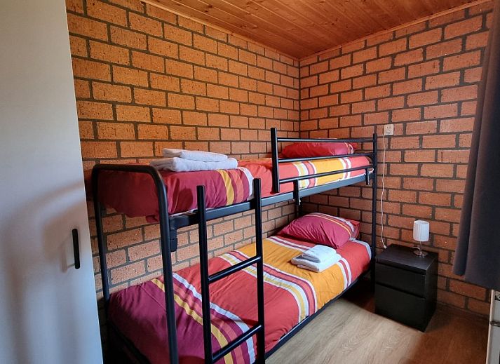 Buitenkant van vakantiehuis De Blenck 66 in Callantsoog, omringd door groene tuin aan de Noordzeekust, Noord-Holland.