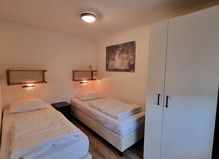 Buitenzijde van vakantiehuis De Blenck 69 in Callantsoog, Noordzeekust, omgeven door groene tuin en zonnig terras.